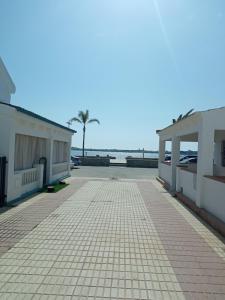 ein Parkplatz mit zwei Gebäuden und einer Palme in der Unterkunft Cornise in El Rompido + 4 Fotos