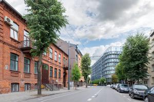 une rue avec des voitures garées sur le bord de la route dans l'établissement Prestigious city center apartment with free parking by Polo Apartments, à Kaunas