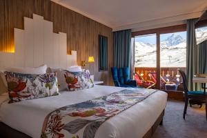 um quarto de hotel com uma cama e vista para a montanha em Hôtel Courcheneige em Courchevel