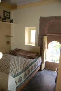 a bedroom with a bed and a window at Bristows Haveli Homestay in Jodhpur