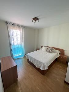 a bedroom with a bed and a window at Apartamento Gijon con plaza de garaje. in Gijón