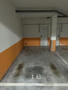 an empty parking lot with the number in a parking garage at Apartamento Gijon con plaza de garaje. in Gijón