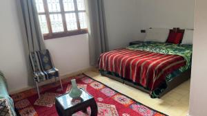 a bedroom with a bed and a vase on a table at Ourika lodge the healing place in Tafza