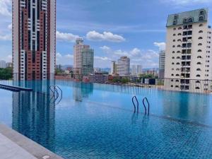 uma piscina com dois cisnes de metal na água em Comfy & Cozy Chambers KL, Near PWTC & Sunway Putra Mall em Kuala Lumpur