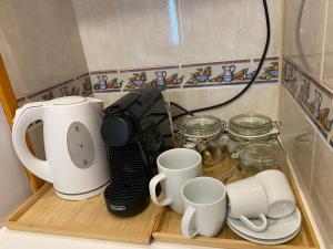 cafetera y tazas en una estantería de madera en Studio La Carihuela, en Torremolinos