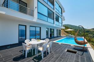 a patio with a table and chairs next to a swimming pool at Villa Bojana in Tivat