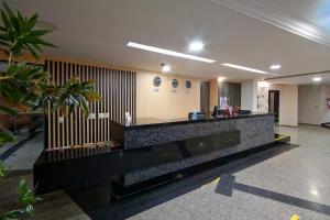 an office lobby with a reception desk and plants at Fênix Hotel Campinas in Campinas