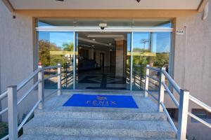 una puerta delantera de un edificio con una alfombra azul de bienvenida en Fênix Hotel Campinas, en Campinas