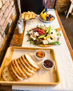 uma mesa com uma bandeja de pão e um prato de comida em Castle View em Saschiz