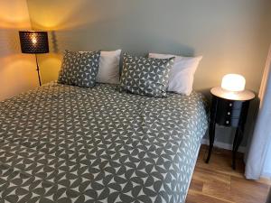 1 dormitorio con 1 cama con almohadas grises y blancas en Bella Vie, rust en ontspanning en Haacht