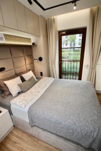 - une chambre avec un grand lit et une fenêtre dans l'établissement Luxury 2-room apartment in Praga-Północ Port Praski, à Varsovie