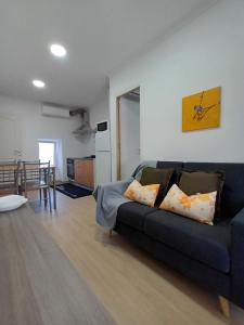 ein Wohnzimmer mit einem blauen Sofa und einer Küche in der Unterkunft Casa Ocre Alojamento Local in Abrantes