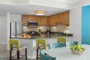 a kitchen with wooden cabinets and a table with a bowl of fruit at Marriott's Grande Ocean in Hilton Head Island