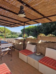 a patio with a table and chairs under a pergola at Affitti Brevi Toscana - Forte Militare Talamonaccio in Fonteblanda