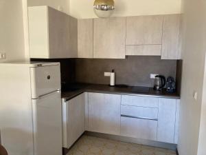 La cuisine est équipée de placards blancs et d'un réfrigérateur. dans l'établissement Grado-Pineta a Mare, à Grado-Pineta
