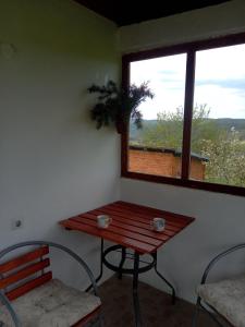 a table and chairs in a room with a window at Kuća za odmor Jutro in Kremna