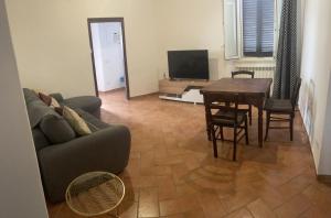 sala de estar con sofá y mesa en Family apartment a Manciano, en Manciano