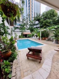 a swimming pool with a bench next to a building at Bodhi Panama City in Panama City