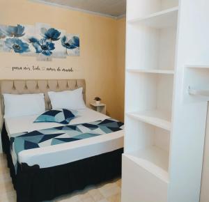 sypialnia z łóżkiem i półką na książki w obiekcie Casa A Beira Mar A 1 Min A Pé Da Praia No Centro De Unamar Cabo-Frio w mieście Cabo Frio