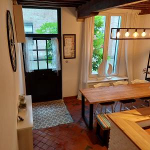 een keuken en eetkamer met een tafel en ramen bij Huize Amoras in Antwerpen