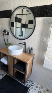 a bathroom with a sink and a mirror at Gîte la ruelle in Remiremont