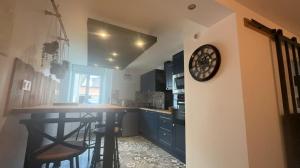 a kitchen with a counter and a clock on a wall at Gîte la ruelle in Remiremont