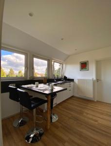 a kitchen with a table and two chairs and two windows at Refugium in Nortrup in Nortrup