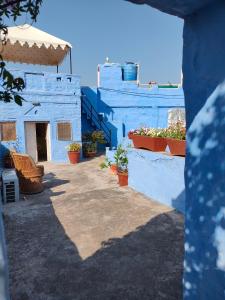 ein blaues Gebäude mit Topfpflanzen davor in der Unterkunft Bristows Haveli Homestay in Jodhpur