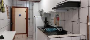 a kitchen with a black counter top in a room at Apto na quadra do mar em Meia Praia Itapema, 2 dorm, 6 pessoas in Itapema