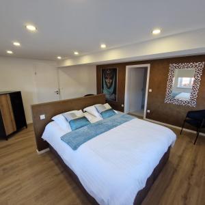 1 dormitorio con 1 cama blanca grande con almohadas azules en chambres d'hotes chez Linda Stéphane le passé composé, 