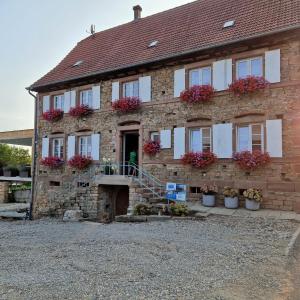 una casa de ladrillo con macetas de flores en la parte delantera en chambres d'hotes chez Linda Stéphane le passé composé, 