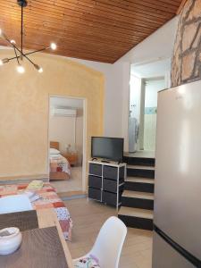 ein Wohnzimmer mit einem TV und ein Schlafzimmer in der Unterkunft Apartment Kiwi in Rabac