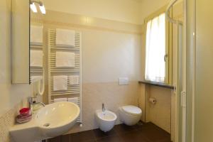 a bathroom with a sink and a toilet and a mirror at Hotel Rosignano in Rosignano Solvay