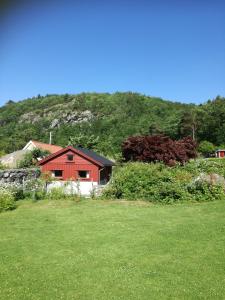 een rood huis in een veld van groen gras bij Not far from famous Pulpit Rock and Stavanger in Strand