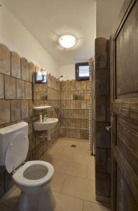 a bathroom with a toilet and a sink at Hollóköves Vendégházak in Hollókő