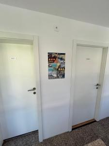 twee deuren in een kamer met een foto aan de muur bij Azimut Hiša in Tolmin