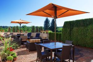 a patio with a table and chairs and an umbrella at Courtyard Rochester East / Penfield in Rochester
