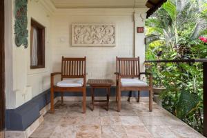 twee stoelen en een tafel op een veranda bij Nusa Indah Candidasa in Candidasa