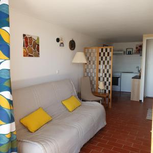 een woonkamer met een bank met twee gele kussens bij Gites Pleine Nature Belledonne in Saint-Martin-dʼArdèche
