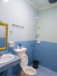 baño azul y blanco con aseo y lavamanos en Miri Morsjaya HOMESTAY, en Miri