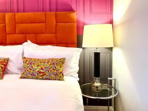 um quarto com uma cama e uma mesa com um candeeiro em Incredible Apartment - Amazing Location - Free Parking & WiFi! em Poole