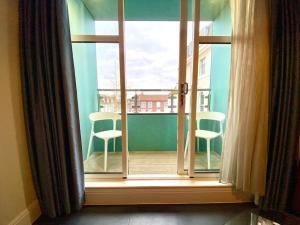 uma janela aberta com 2 cadeiras numa varanda em Incredible Apartment - Amazing Location - Free Parking & WiFi! em Poole