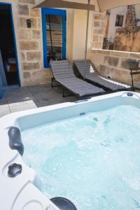 a large jacuzzi tub with two benches in a yard at Mandera's Boutique Suites & Dorms in Valletta