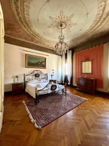 a bedroom with a bed and a chandelier at Dimora '800 in Ferrara