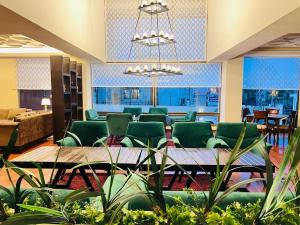 a waiting room with green chairs and a table at Shelton's Suites Bhurban in Bhurban