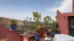 d'un balcon avec des plantes en pot et une table. dans l'établissement Ourika lodge the healing place, à Tafza