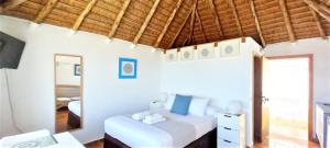 a bedroom with a white bed and a wooden ceiling at Mandala Bungalows - Adults Only in Los Caños de Meca