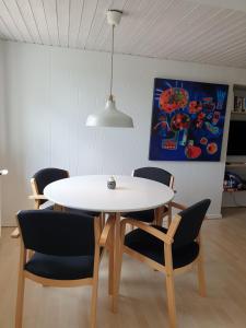 ein Esszimmer mit einem weißen Tisch und Stühlen in der Unterkunft St. Strandbygaard in Åkirkeby
