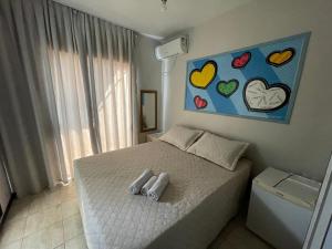 1 dormitorio con 1 cama con corazones en la pared en Shallom Hotel, en Balneário Camboriú