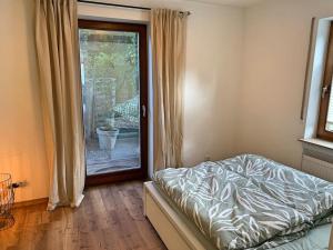 a bedroom with a bed and a sliding glass door at Ferienwohnung am Bodensee in Singen